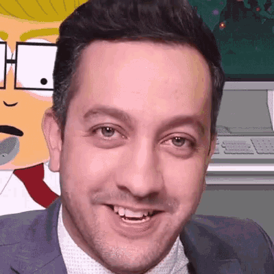 a man in a suit and tie smiles in front of a cartoon character