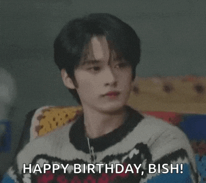 a young man is wearing a sweater and smiling while saying `` happy birthday , bisha '' .