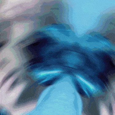 a blurred image of a person 's face with a blue and pink background