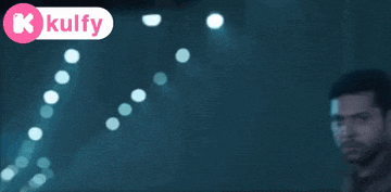a blurred image of a man in a dark room with the words kulfy in the corner