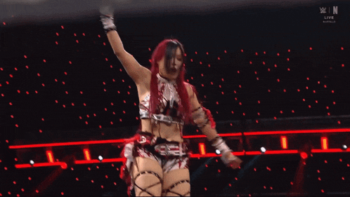 a female wrestler is flying through the air in front of a sign that says raw