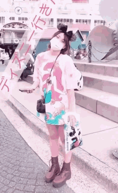a woman wearing a mask is holding a bag that says disney resort on it