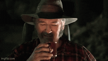 a man in a cowboy hat is drinking a beer from a can .