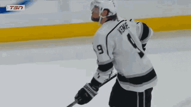 a hockey player with the number 9 on his jersey is kneeling on the ice