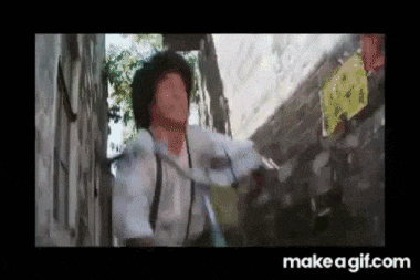 a man is standing next to a wall with a sign on it that says make a gif.com