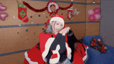 a woman in a santa hat has the letter g on her hat