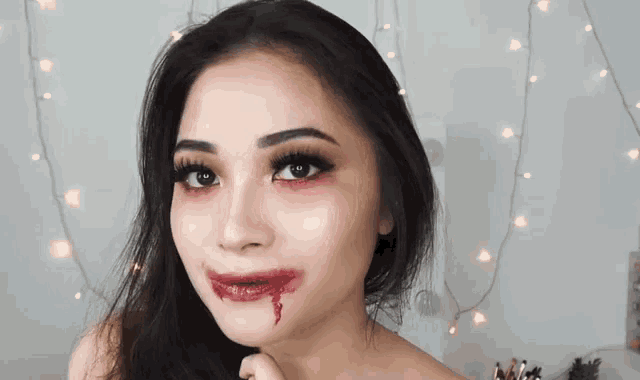a close up of a woman 's face with blood dripping from her mouth .