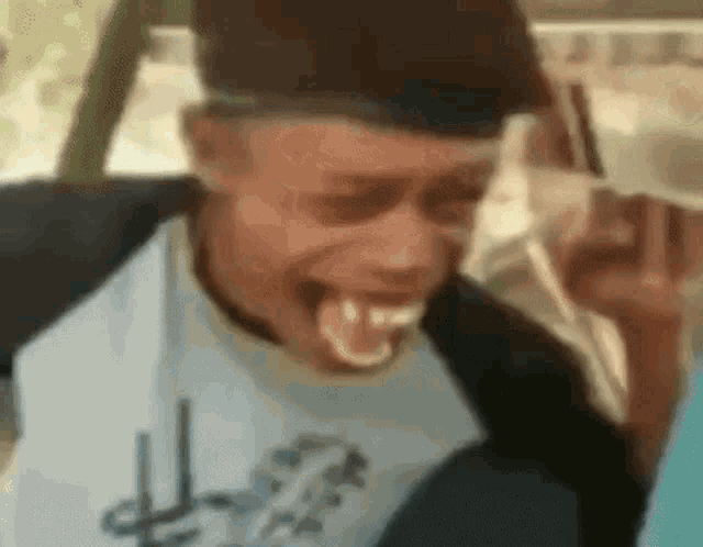 a man is making a funny face with his tongue out while sitting in a car .