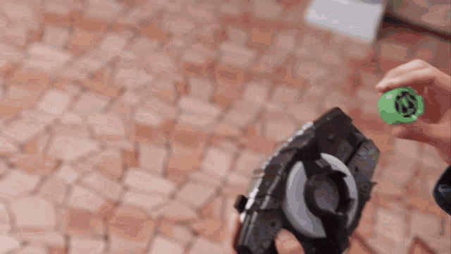 a person is holding a toy with a green item that says ' avengers ' on it