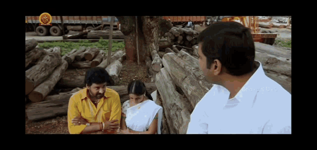 a man in a yellow shirt is talking to two other men