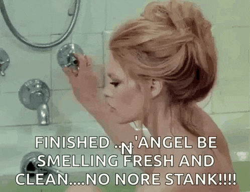 a naked woman is taking a bath in a bathtub and holding a shower head .