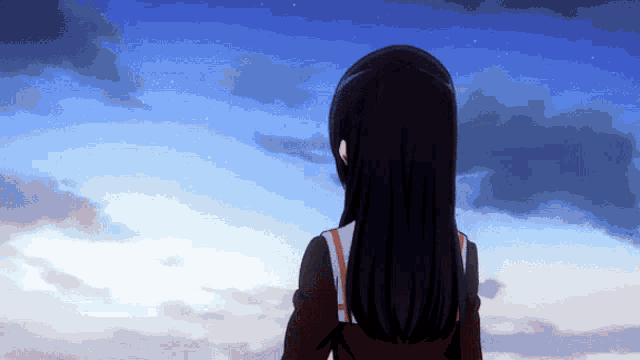 a girl stands in front of a blue sky with clouds