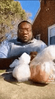 a man sitting on the ground with a bag of food