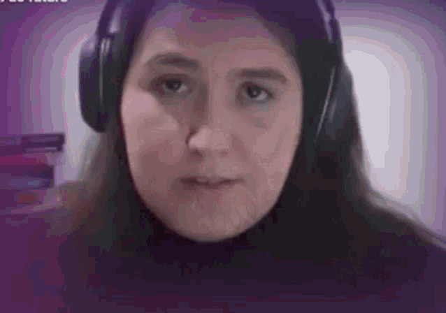 a woman wearing headphones is sitting in front of a computer screen .