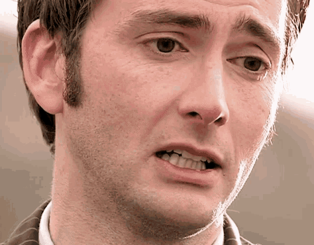a close up of a man 's face with his mouth open and his teeth showing