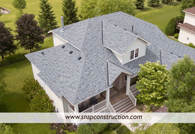 an aerial view of a white house with a blue roof and the website snapconstruction.com