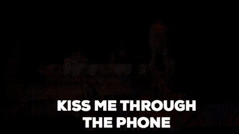 a man looking at his phone with the words kiss me through the phone