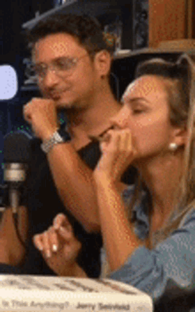 a man and a woman are kissing in front of a microphone