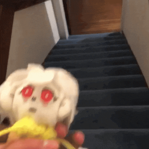 a stuffed animal with red eyes is walking down stairs .