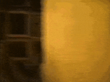 a yellow wall with a window in the background .