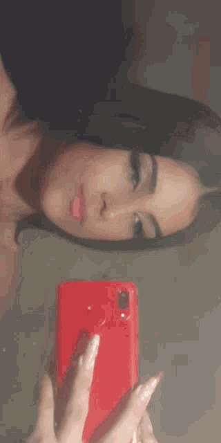a woman is taking a selfie with her cell phone in a mirror .