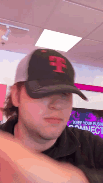 a man wearing a black hat with a red letter f on it