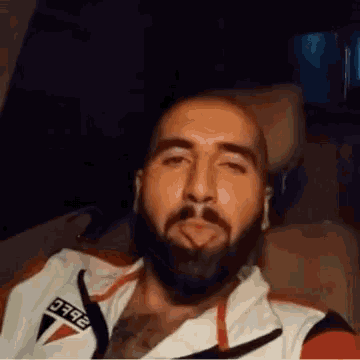 a man with a beard is sticking his tongue out while wearing a shirt with the number 792 on the front
