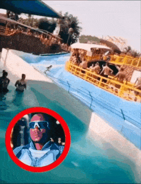 a man wearing sunglasses stands in front of a water park