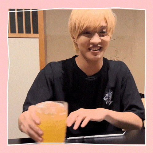 a man in a black shirt holds a glass of beer