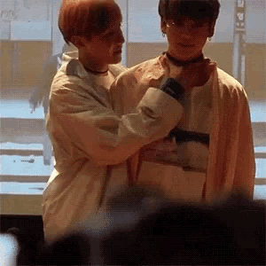 two men are standing next to each other in a room .