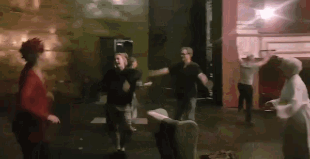 a group of people are dancing in a room