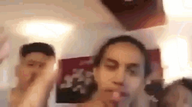 a group of people are standing next to each other in a room and making funny faces .