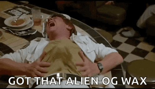 a man is laying on a checkered floor with the words got that alien og wax written above him