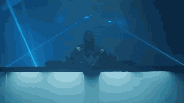 a silhouette of a person in a dark room with blue lights