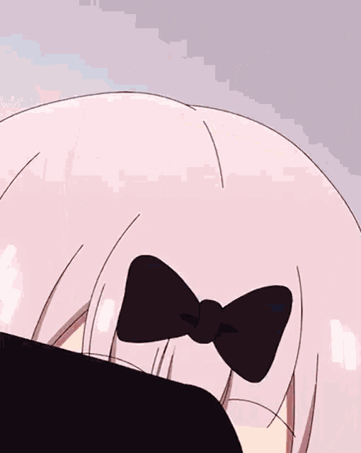 a close up of a anime girl with a bow on her head .