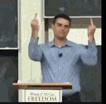 a man is giving a speech at a podium that says freedom .