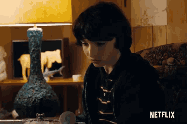 a young boy is sitting in a chair in front of a netflix ad