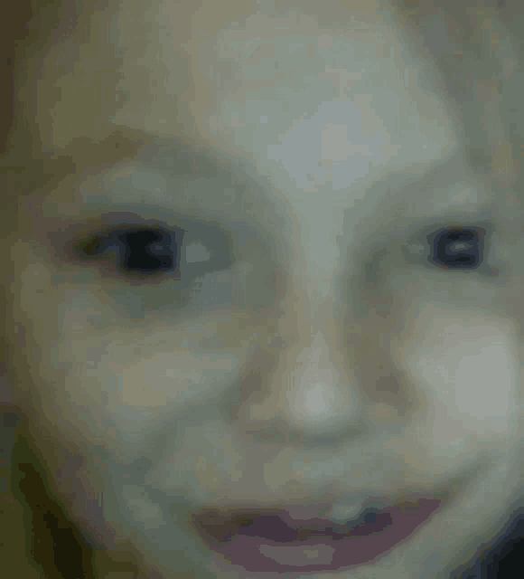 a close up of a child 's face with a smile .