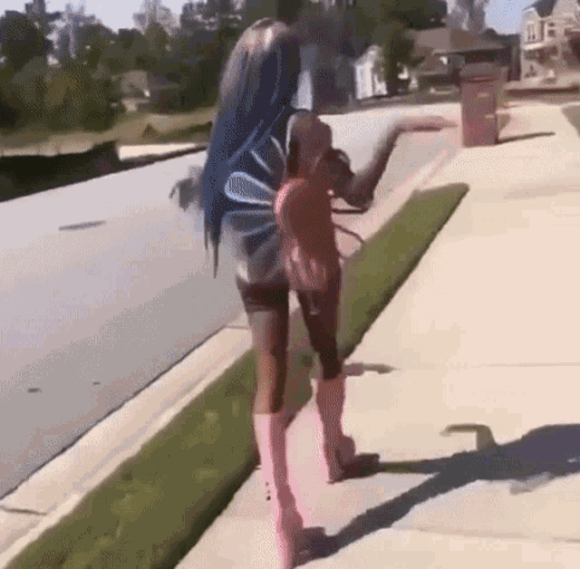 a woman is walking down a sidewalk wearing a fairy costume and pink boots .