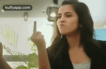 a woman is giving the middle finger to someone in a room .