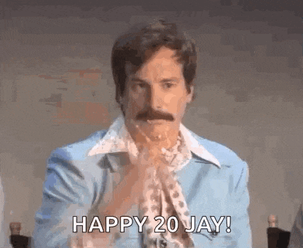 a man with a mustache is wearing a blue jacket and a scarf and says `` happy 20 jay '' .