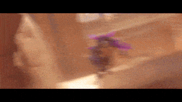 a blurry picture of a person wearing a purple hat .