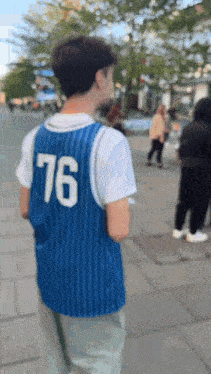 a person wearing a blue jersey with 76 on the back