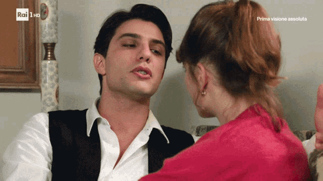 a man and a woman are looking at each other and the words prima visione absolute are on the bottom