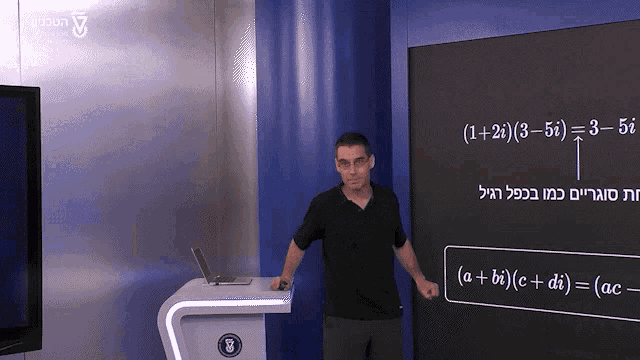 a man stands in front of a blackboard that says 1 + 2 = 3