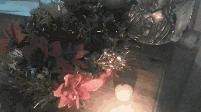 a candle sits on a table next to a christmas tree and decorations