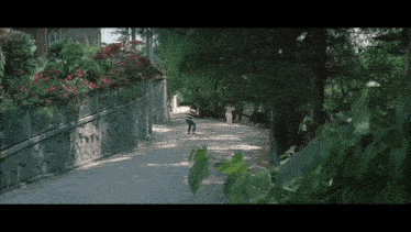 a man and woman are walking down a narrow street .