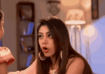 a woman with a surprised look on her face is sitting in a living room
