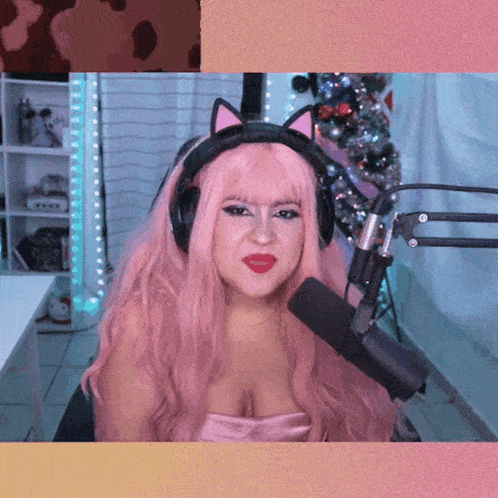 a woman with pink hair is wearing headphones and a microphone