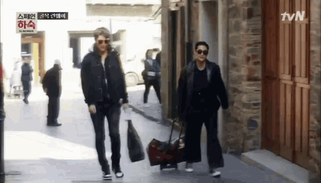 two men are walking down a street with a tvn logo in the corner